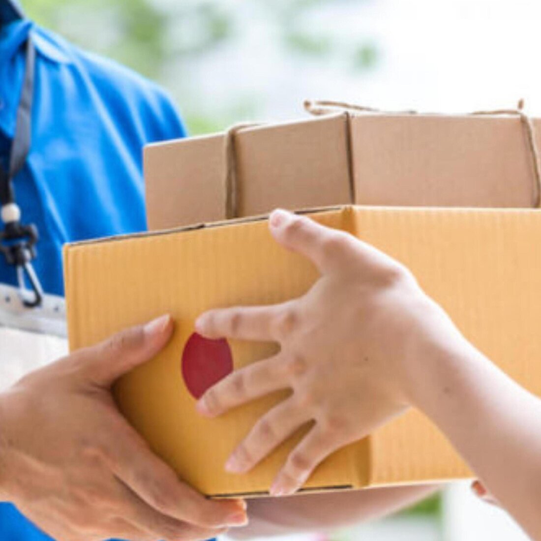 A Soldiers Enterprises rider handing a parcel to a customer at the doorstep